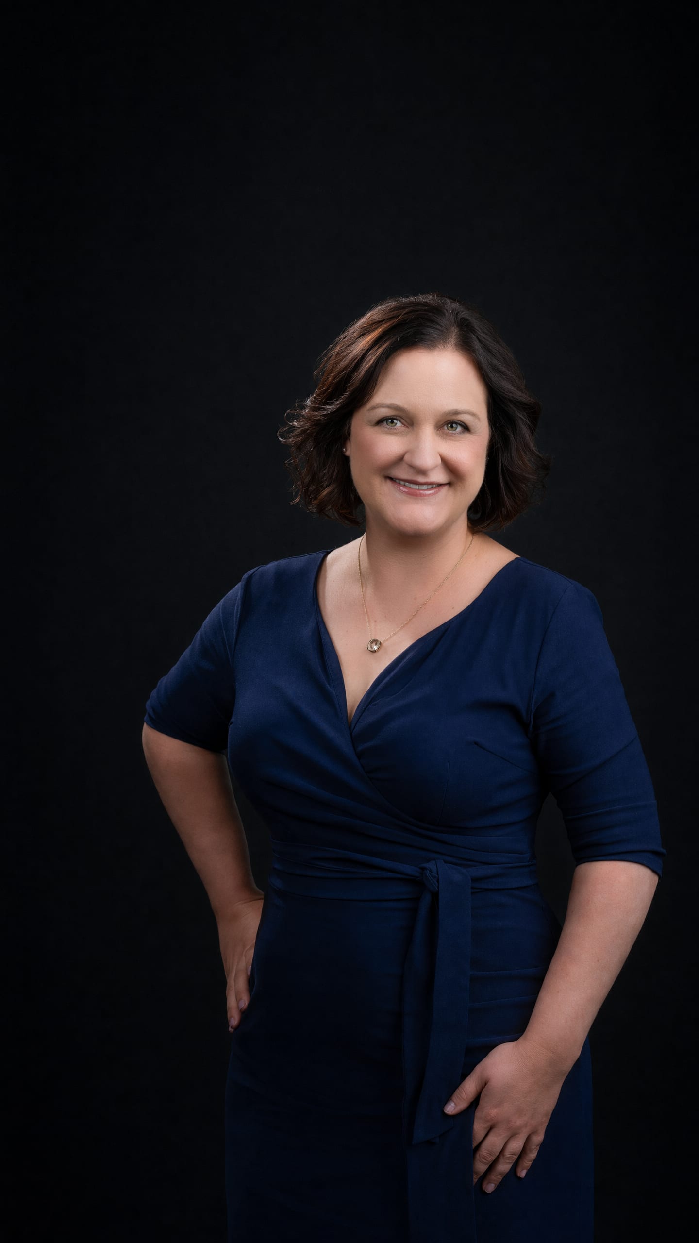 Melissa Nyman, Deputy Managing Partner of Nyman Turkish PC, in a navy dress against a dark field.